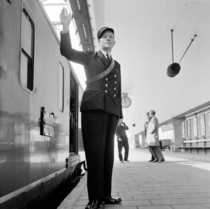 854530 Afbeelding van een hoofdconducteur van N.S. voor vertrek van de sneltrein naar Enschede op het perron van het ...